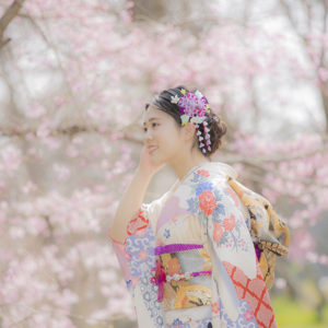 桜を背景の振袖の女性